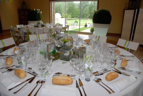 a white table with glasses and silverware on it at Château de Mazières in Tendu