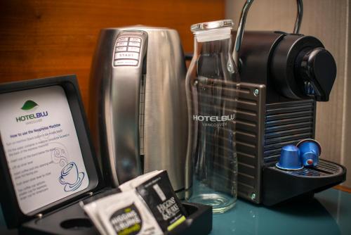 a table with a camera a phone and a bottle of water at Hotel BLU in Vancouver