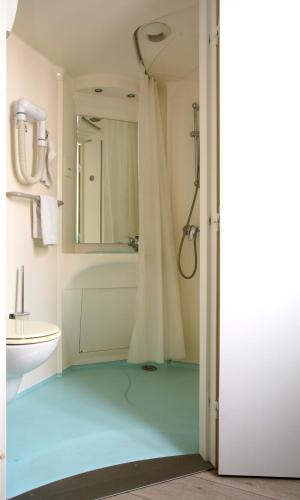 a bathroom with a shower and a toilet and a sink at Hotel De Rosny in Tours