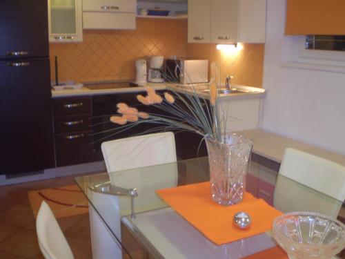 a vase with flowers on a glass table in a kitchen at Villa Jelena in Zadar