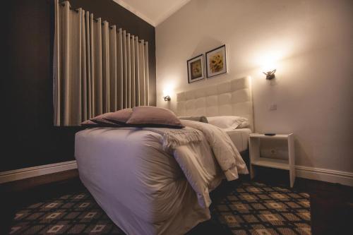 a bedroom with a bed and a window at Palmeiras Guest House Maputo in Maputo