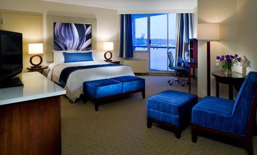a hotel room with a bed and a desk and chairs at Inn At The Quay in New Westminster