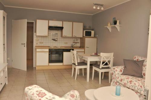 cocina y sala de estar con mesa y sillas en Strandnah, en Horumersiel