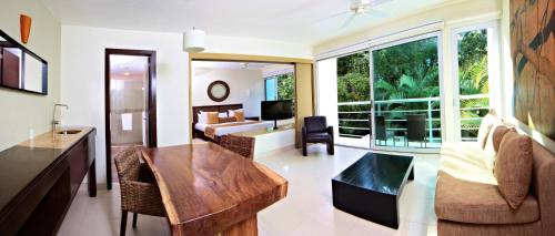 a living room with a large window and a bedroom at Bahia Principe Luxury Sian Ka´an - Adults Only - All Inclusive in Akumal