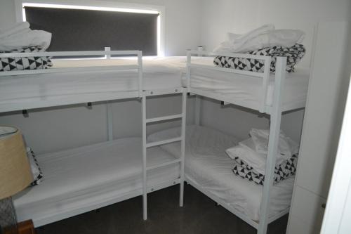 two white bunk beds in a room at Yarrawonga Holiday Park in Yarrawonga