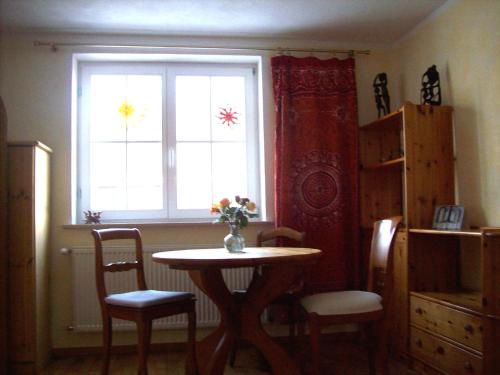 - une table et des chaises dans une chambre avec fenêtre dans l'établissement Haus Diana, à Badenweiler