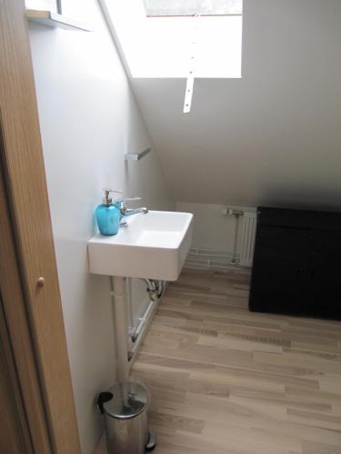 a bathroom with a white sink and a window at Grand-Inn Bar and Bed in Sau&eth;&aacute;rkr&oacute;kur