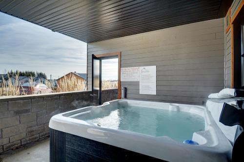 a large bath tub in a room with a window at Le Vallon in Saint-Férréol-les-Neiges