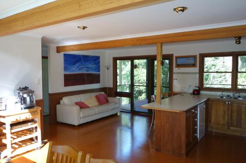 a kitchen and living room with a couch and a table at Ruddles Retreat in Maleny