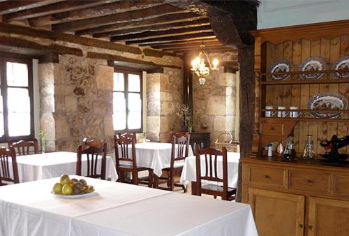 un comedor con mesas y sillas y una mesa con fruta. en Posada Vallejo, en Periedo