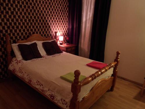 a bedroom with a bed with a wooden headboard at Stansted Airport Lodge in Takeley