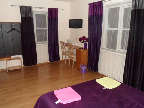 a room with a bed and a table and windows at Stansted Airport Lodge in Takeley