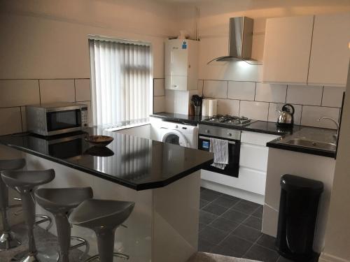 a kitchen with a counter and some stools in it at Marine Lake apartment in West Kirby
