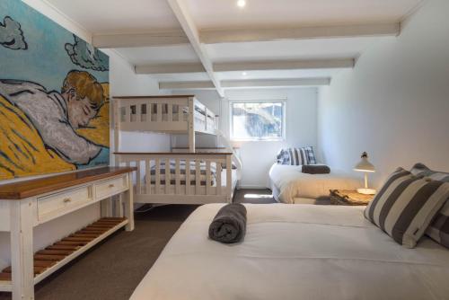 ブレアゴウリーにあるGrand Capella Villa 1のベッドルーム1室(ベッド2台付)が備わります。壁には絵画が飾られています。