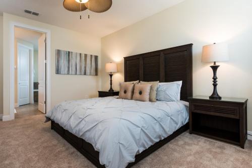 a bedroom with a large bed and two lamps at Disney Dreams Luxury Home with Private Water Park in Orlando