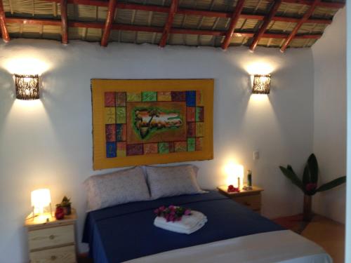 a bedroom with a bed with two lights on the wall at Villa La Caleta in Las Galeras