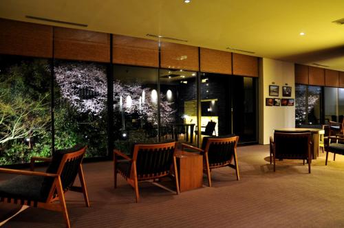 a lobby with chairs and tables and large windows at Ito Yukitei in Ito