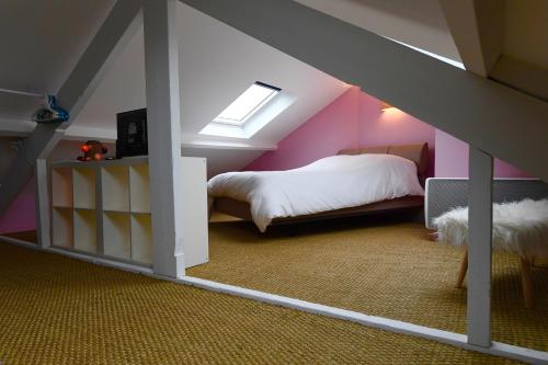 a attic bedroom with a bed and a dog in it at Appartement Week-end in Dunkerque