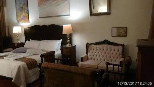 a bedroom with a large bed and a couch at Casa Falleri Boutique Hotel in Lima