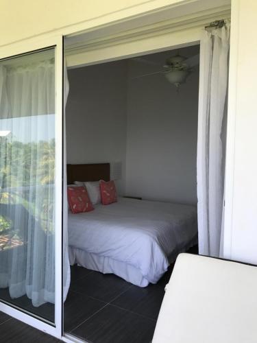 a bedroom with a bed and a sliding glass door at Vista Mare Spectacular Ocean View Top Floor 1-Bedroom Condo, Samana in Santa Bárbara de Samaná