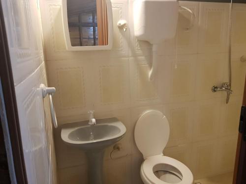 un piccolo bagno con un water e un lavandino di Los Nogales a Punta Del Diablo