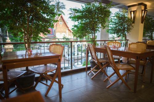a restaurant with two tables and chairs and a balcony at Lao Orchid Hotel in Vientiane
