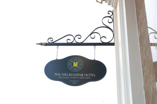 a sign for the melbourne hotel hanging on a window at The Melbourne Hotel in Ninh Binh