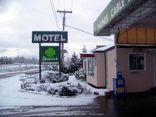 a motel sign in the snow next to a store at Shamrock Motel in Bellingham