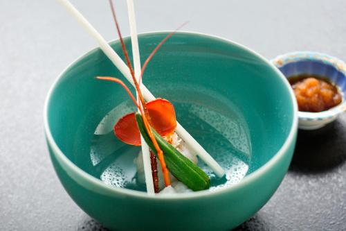 a green bowl with some food in it at Ryokan KANADE in Kyoto