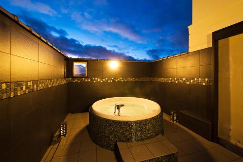 a bathroom with a bath tub in the middle at Ryokan KANADE in Kyoto