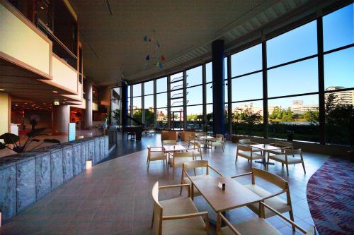 a restaurant with tables and chairs and large windows at Biwako Ryokusuitei in Otsu