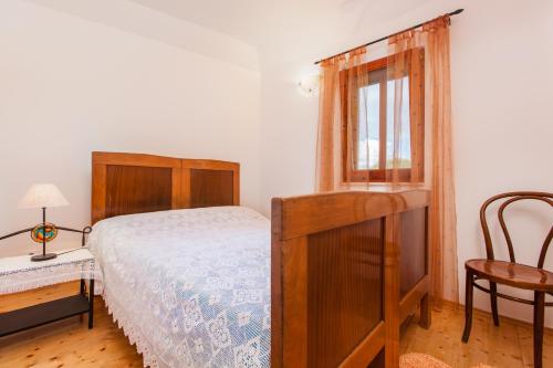a bedroom with a bed and a window and a chair at Countryside Family Villa with Private Pool in Donje Selo na Šolti