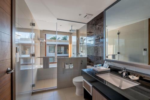 a bathroom with a sink and a toilet and a mirror at Henann Crystal Sands Resort in Boracay