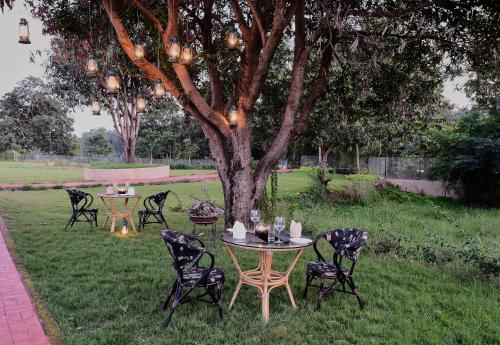 a group of tables and chairs under a tree at Sterling Kanha in Kānha