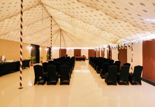 a room with black chairs and a ceiling at Sterling Kanha in Kānha