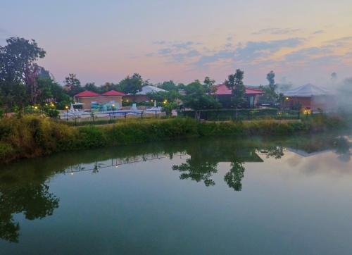 a view of a river with buildings in the background at Sterling Kanha in Kānha