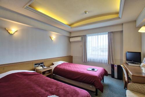 Postel nebo postele na pokoji v ubytování Okinawa Hotel