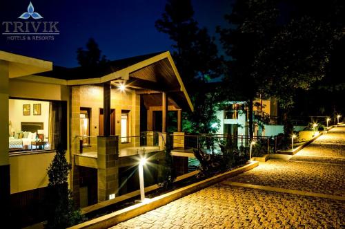 a house with lights on a street at night at Trivik Hotels & Resorts, Chikmagalur in Chikmagalūr