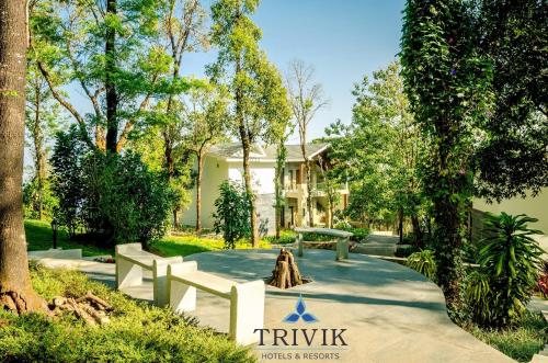 a park with a building in the background with trees at Trivik Hotels & Resorts, Chikmagalur in Chikmagalūr
