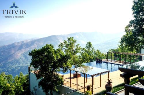 a swimming pool with a view of a mountain at Trivik Hotels & Resorts, Chikmagalur in Chikmagalūr
