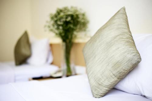 a pillow sitting on top of a bed with a plant at Star 3 Hotel and Residence in Rayong