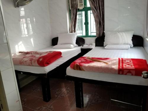 two beds sitting next to each other in a room at Cebu Hostel in Hong Kong