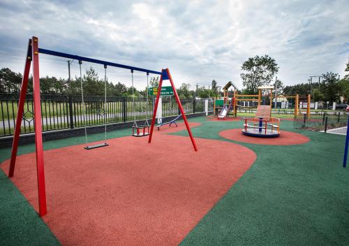 a playground with two swings and a slide at Hotel KARO in Radom