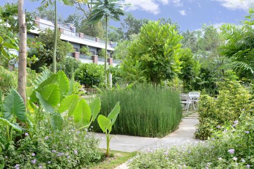 a garden with tall grass and a building at Purple Palms Resort & Spa in Kushālnagar
