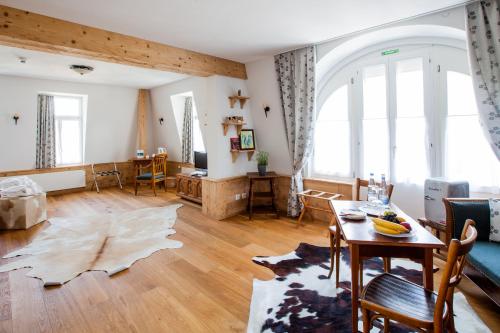 a living room with a table and a couch at Carlton-Europe Vintage Adults Hotel in Interlaken