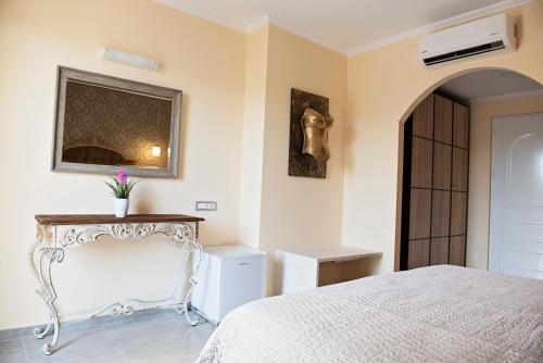a bedroom with a bed and a table and a mirror at Hotel Kalithea in Kallithea Rhodes