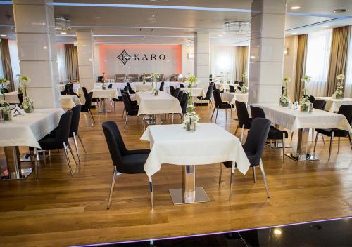 a banquet hall with white tables and black chairs at Hotel KARO in Radom