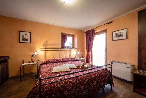 a bedroom with a bed with a red blanket and a window at Bed & Breakfast Lo Teisson in Aosta