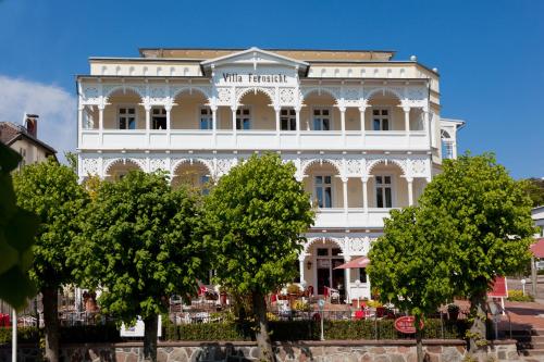 een wit gebouw met bomen ervoor bij Villa Fernsicht - Apt. 07 in Ostseebad Sellin