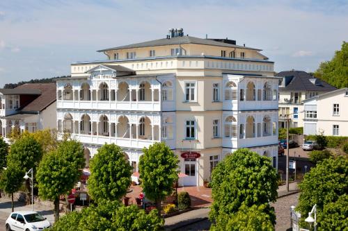 um grande edifício branco com árvores em frente em Villa Fernsicht - Apt. 08 em Ostseebad Sellin